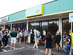 Image of the outside of Cafe Kaila with multiple people waiting to get seated.